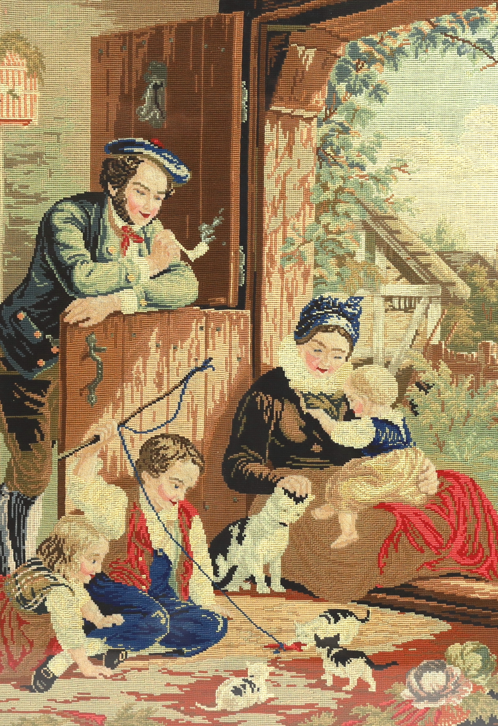 A framed 19th century Berlin woodwork embroidery of a Scottish farmhouse scene, embroidered with children and kittens playing, a mother, baby and father smoking a clay pipe, wearing a Tam o'Shanter leaning on a door, 53c